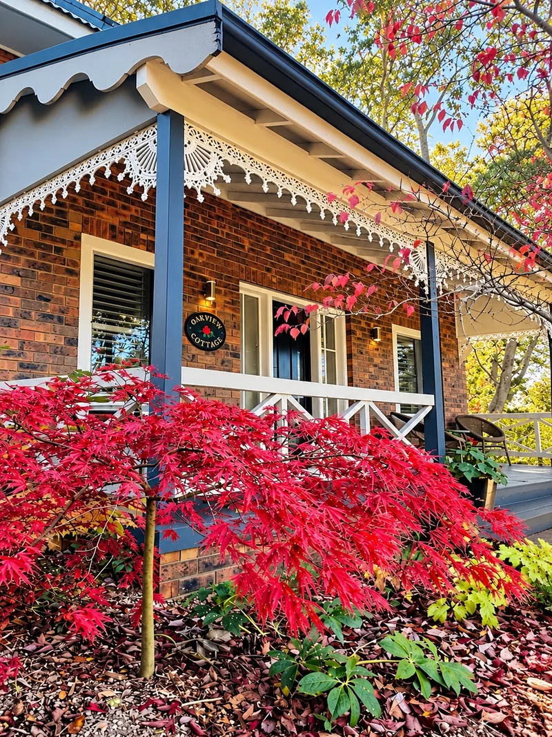 Portree Cottage front verandah framed by brilliant red Japanese maple foliage